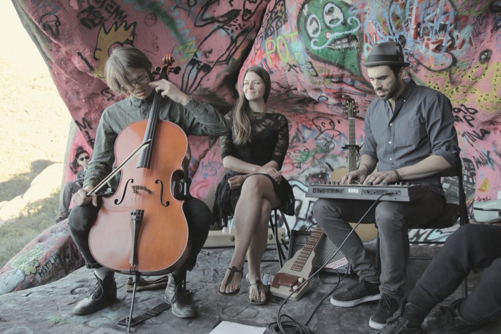 A trio playing inside a painted cave