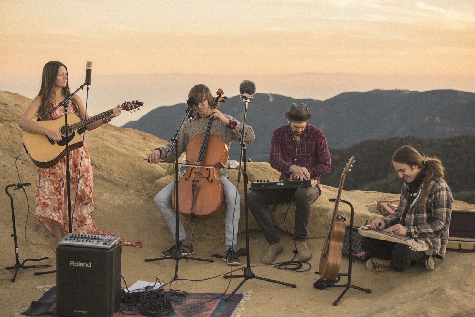 A quartet playing on sandstone rocks above the canyon at dusk